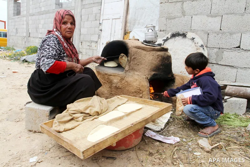 Palestinian women bake bread on March 30, 2016, in Khan Yunis, in the southern Gaza Strip as Palestinians mark Land Day. March 30 marks Land Day, the annual commemorations of the killing by police of six Arab citizens in...