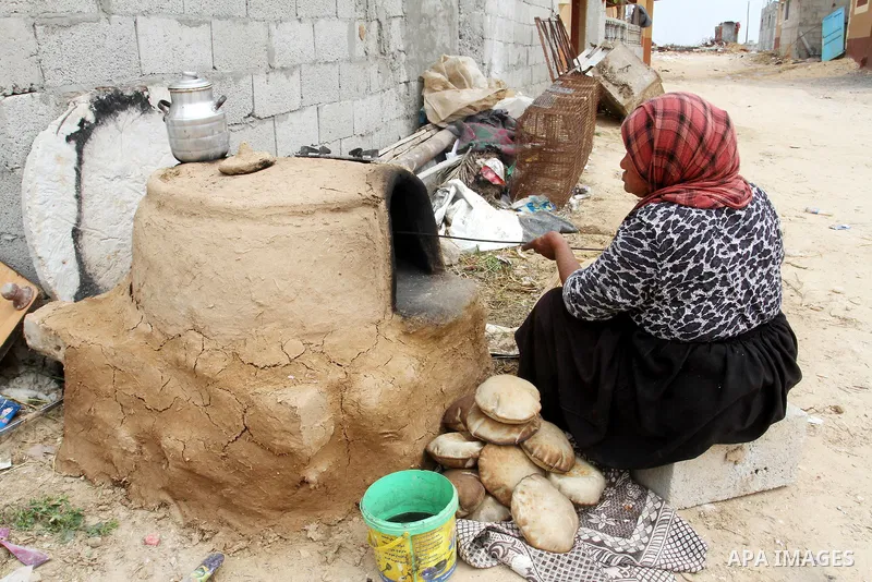 Palestinian women bake bread on March 30, 2016, in Khan Yunis, in the southern Gaza Strip as Palestinians mark Land Day. March 30 marks Land Day, the annual commemorations of the killing by police of six Arab citizens in...