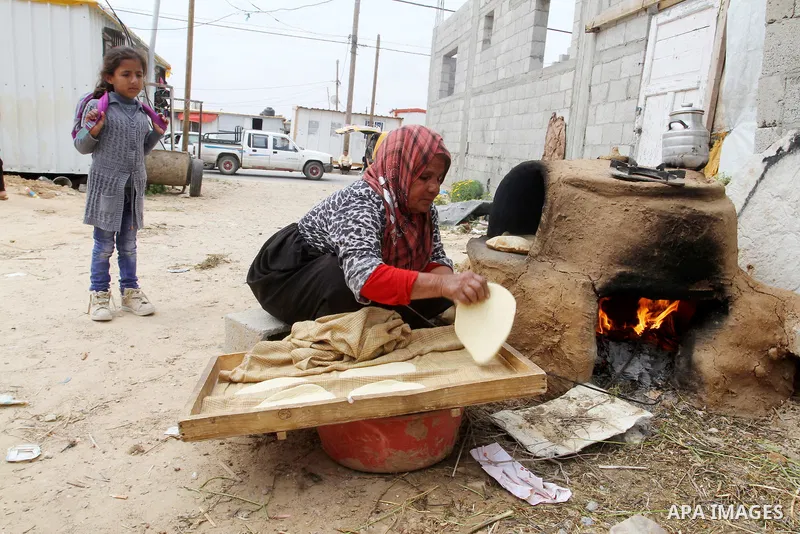 Palestinian women bake bread on March 30, 2016, in Khan Yunis, in the southern Gaza Strip as Palestinians mark Land Day. March 30 marks Land Day, the annual commemorations of the killing by police of six Arab citizens in...