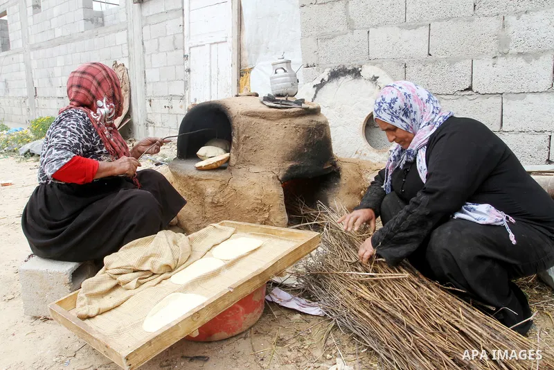 Palestinian women bake bread on March 30, 2016, in Khan Yunis, in the southern Gaza Strip as Palestinians mark Land Day. March 30 marks Land Day, the annual commemorations of the killing by police of six Arab citizens in...