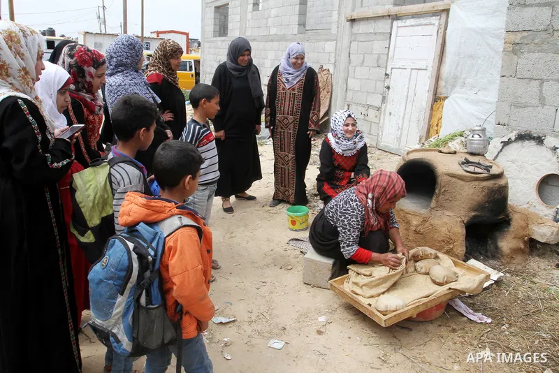 Palestinian women bake bread on March 30, 2016, in Khan Yunis, in the southern Gaza Strip as Palestinians mark Land Day. March 30 marks Land Day, the annual commemorations of the killing by police of six Arab citizens in...