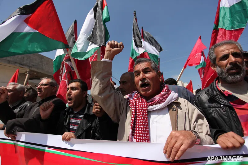 Palestinian protesters wave their national flags during a rally to mark Land Day, near the Nahal Oz crossing east of Gaza City on March 31, 2016. The annual commemorations of the killing by police of six Arab citizens in...