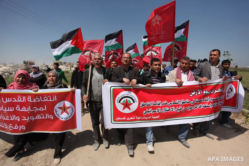 Palestinian protesters wave their national flags during a rally to mark Land Day, near the Nahal Oz crossing east of Gaza City on March 31, 2016. The annual commemorations of the killing by police of six Arab citizens in...