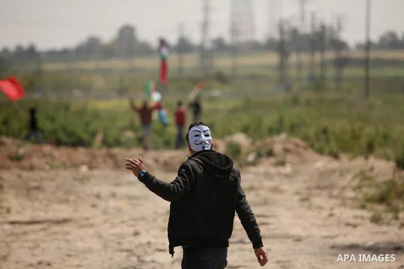 Palestinian protesters wave their national flags during a rally to mark Land Day, near the Nahal Oz crossing east of Gaza City on March 31, 2016. The annual commemorations of the killing by police of six Arab citizens in...