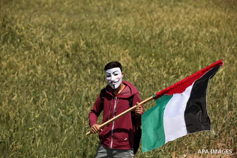 Palestinian protesters wave their national flags during a rally to mark Land Day, near the Nahal Oz crossing east of Gaza City on March 31, 2016. The annual commemorations of the killing by police of six Arab citizens in...