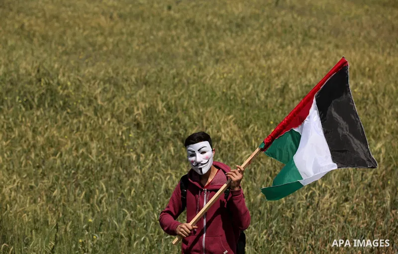 Palestinian protesters wave their national flags during a rally to mark Land Day, near the Nahal Oz crossing east of Gaza City on March 31, 2016. The annual commemorations of the killing by police of six Arab citizens in...