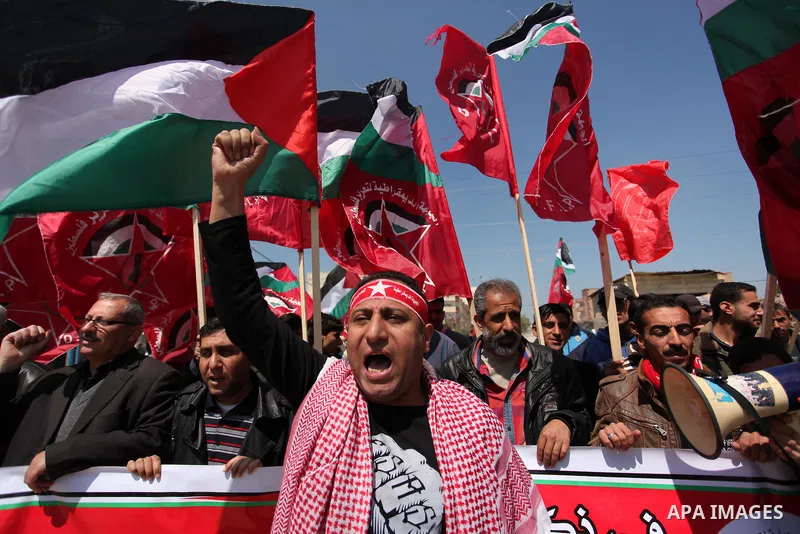 Palestinian protesters wave their national flags during a rally to mark Land Day, near the Nahal Oz crossing east of Gaza City on March 31, 2016. The annual commemorations of the killing by police of six Arab citizens in...