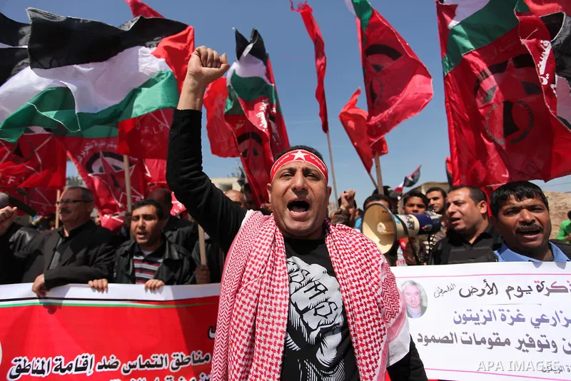 Palestinian protesters wave their national flags during a rally to mark Land Day, near the Nahal Oz crossing east of Gaza City on March 31, 2016. The annual commemorations of the killing by police of six Arab citizens in...