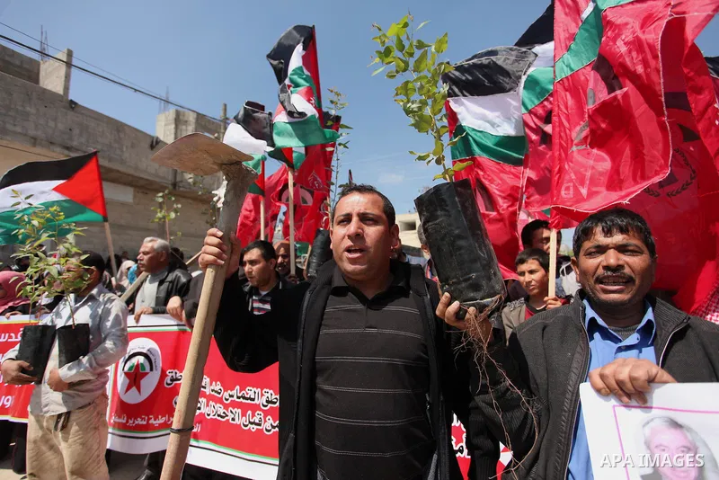Palestinian protesters wave their national flags during a rally to mark Land Day, near the Nahal Oz crossing east of Gaza City on March 31, 2016. The annual commemorations of the killing by police of six Arab citizens in...