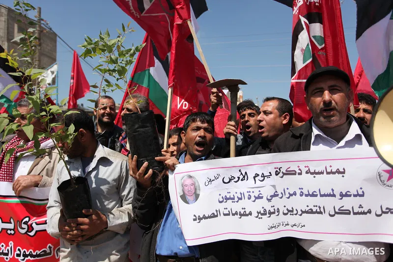 Palestinian protesters wave their national flags during a rally to mark Land Day, near the Nahal Oz crossing east of Gaza City on March 31, 2016. The annual commemorations of the killing by police of six Arab citizens in...