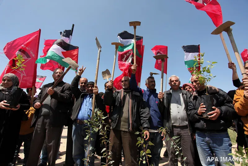 Palestinian protesters wave their national flags during a rally to mark Land Day, near the Nahal Oz crossing east of Gaza City on March 31, 2016. The annual commemorations of the killing by police of six Arab citizens in...