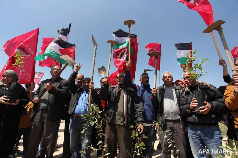 Palestinian protesters wave their national flags during a rally to mark Land Day, near the Nahal Oz crossing east of Gaza City on March 31, 2016. The annual commemorations of the killing by police of six Arab citizens in...