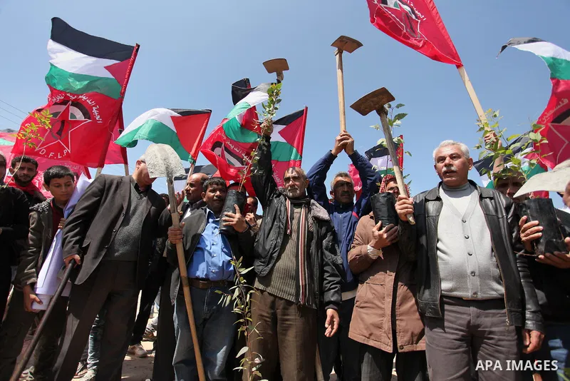 Palestinian protesters wave their national flags during a rally to mark Land Day, near the Nahal Oz crossing east of Gaza City on March 31, 2016. The annual commemorations of the killing by police of six Arab citizens in...