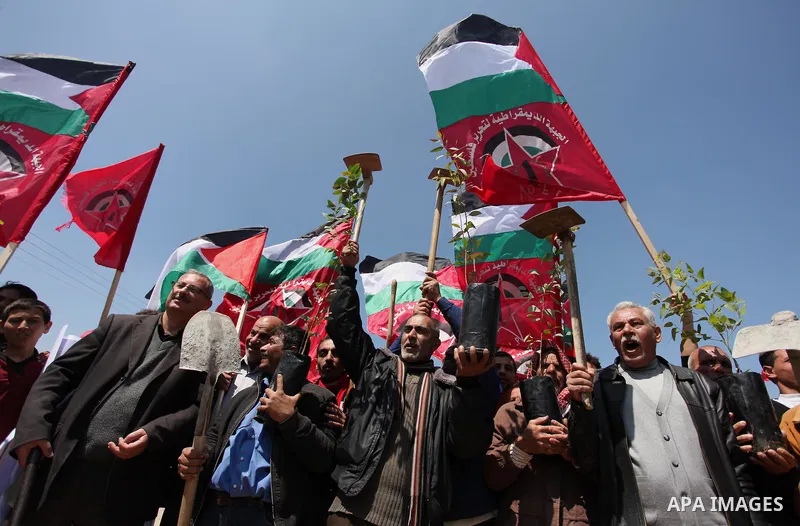 Palestinian protesters wave their national flags during a rally to mark Land Day, near the Nahal Oz crossing east of Gaza City on March 31, 2016. The annual commemorations of the killing by police of six Arab citizens in...