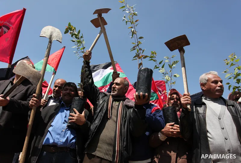 Palestinian protesters wave their national flags during a rally to mark Land Day, near the Nahal Oz crossing east of Gaza City on March 31, 2016. The annual commemorations of the killing by police of six Arab citizens in...