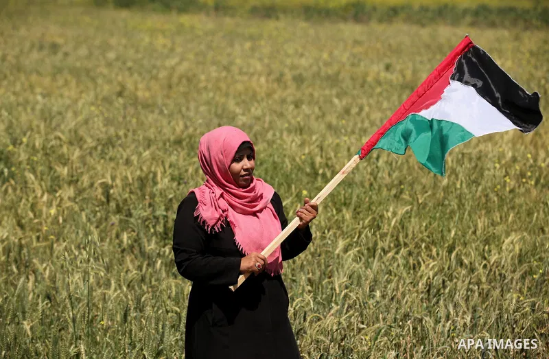 Palestinian protesters wave their national flags during a rally to mark Land Day, near the Nahal Oz crossing east of Gaza City on March 31, 2016. The annual commemorations of the killing by police of six Arab citizens in...