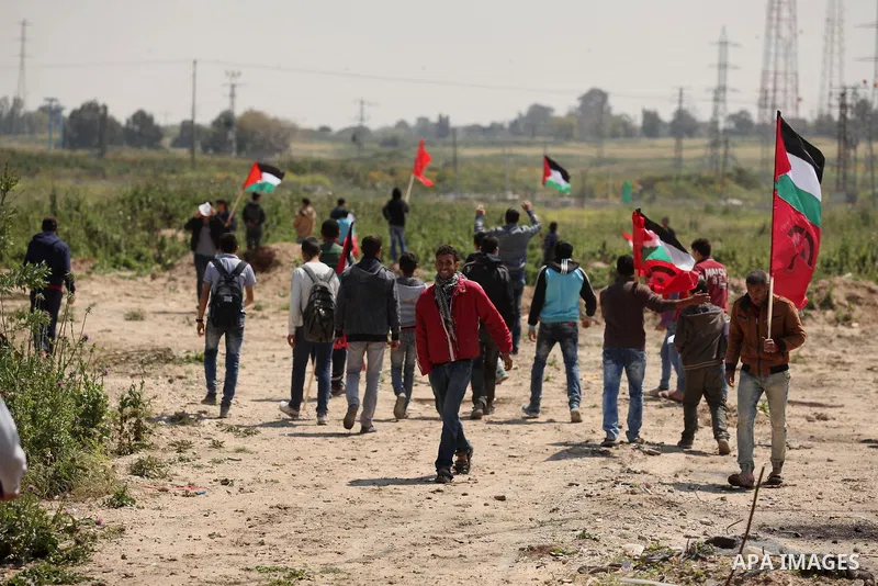 Palestinian protesters wave their national flags during a rally to mark Land Day, near the Nahal Oz crossing east of Gaza City on March 31, 2016. The annual commemorations of the killing by police of six Arab citizens in...