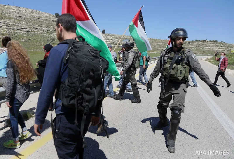 Palestinian protesters scuffle with Israeli border guards during clashes following a march against Palestinian land confiscation on April 1, 2016 in the West Bank village of Nabi Saleh near Ramallah. Photo by Hamza Shala...