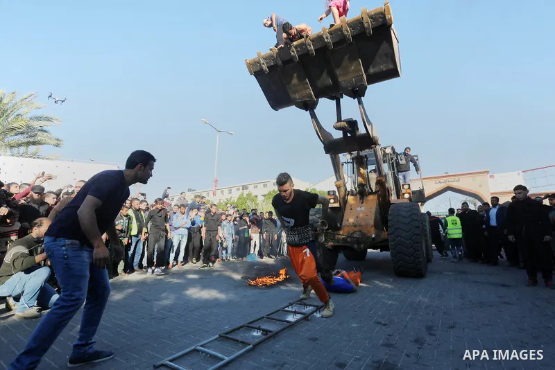 Participants ride in a bulldozer scoop as it is pulled by Palestinian Mohammad Baraka, nicknamed Gaza Samson, during a cultural carnival organized by Gaza Municipality in Gaza City April 1, 2016. Photo by Mohammed Asad