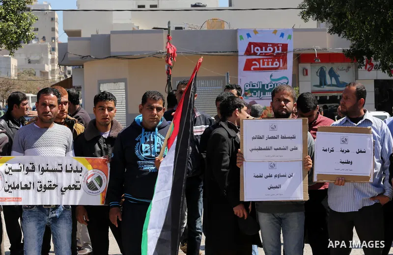 Palestinian supporters of Popular front for Liberation of Palestine (PFLP) hold banners during a protest against the siege of Gaza, in Gaza City, on April 2, 2016. Photo by Mohammed Asad