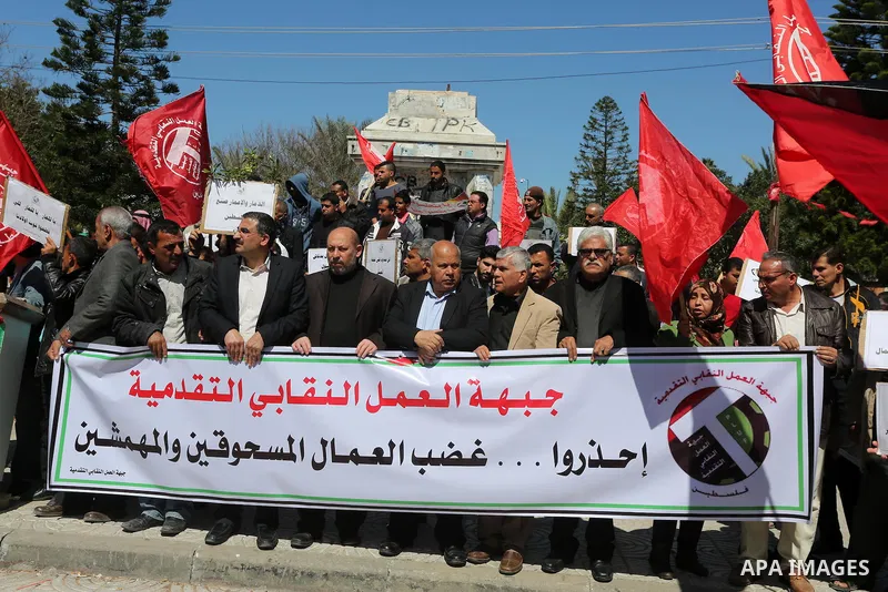 Palestinian supporters of Popular front for Liberation of Palestine (PFLP) hold banners during a protest against the siege of Gaza, in Gaza City, on April 2, 2016. Photo by Mohammed Asad