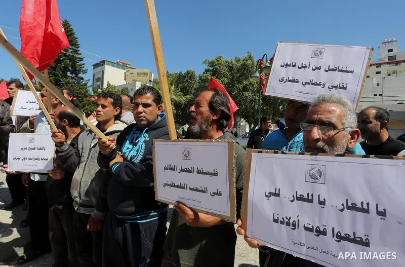 Palestinian supporters of Popular front for Liberation of Palestine (PFLP) hold banners during a protest against the siege of Gaza, in Gaza City, on April 2, 2016. Photo by Mohammed Asad