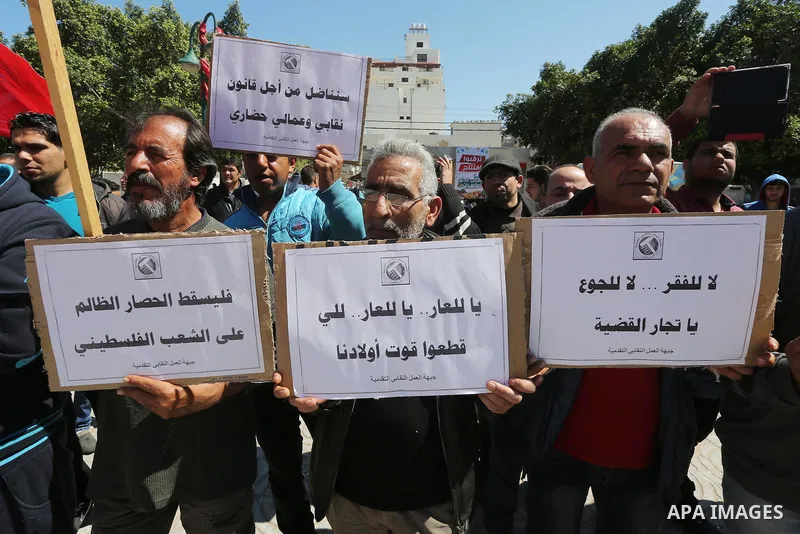 Palestinian supporters of Popular front for Liberation of Palestine (PFLP) hold banners during a protest against the siege of Gaza, in Gaza City, on April 2, 2016. Photo by Mohammed Asad