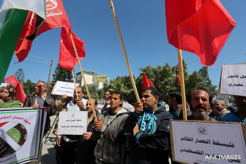 Palestinian supporters of Popular front for Liberation of Palestine (PFLP) hold banners during a protest against the siege of Gaza, in Gaza City, on April 2, 2016. Photo by Mohammed Asad