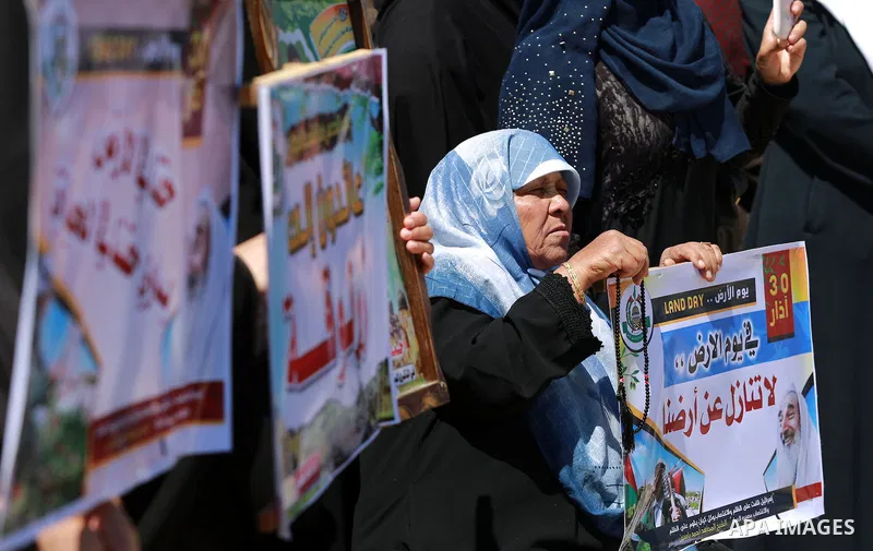 Palestinian women hold banners during a rally marking Land Day, near Eriz crossing in the northern Gaza Strip, on April 2, 2016. Photo by Yasser Qudih