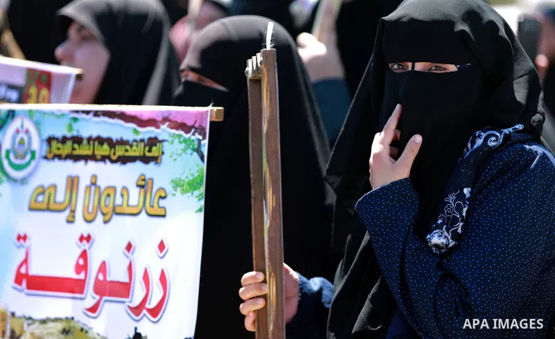 Palestinian women hold banners during a rally marking Land Day, near Eriz crossing in the northern Gaza Strip, on April 2, 2016. Photo by Yasser Qudih