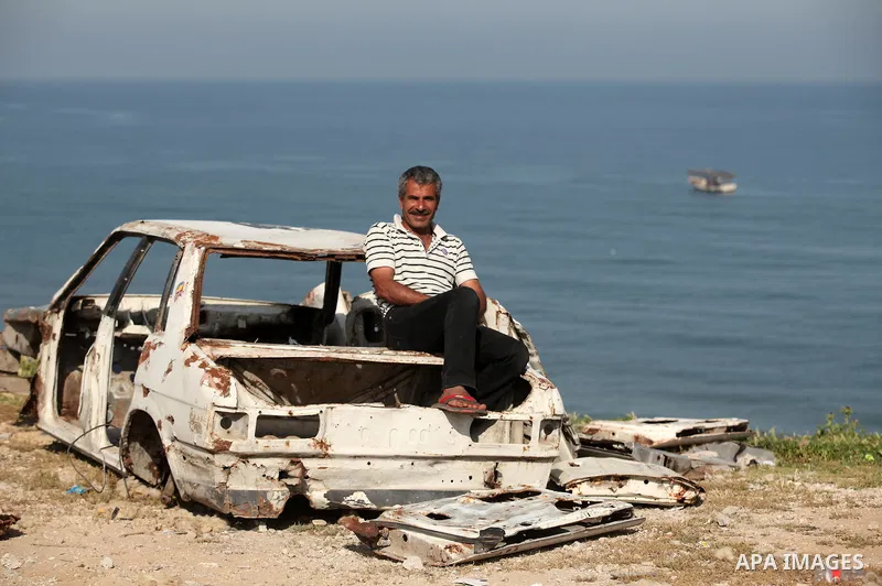 Palestinian fishermen work at the beach in Dair Al Balah in the center of Gaza strip on April 03, 2016. Israel on Sunday extended the distance it permits Gaza fishermen to head out to sea along certain parts of the coast...