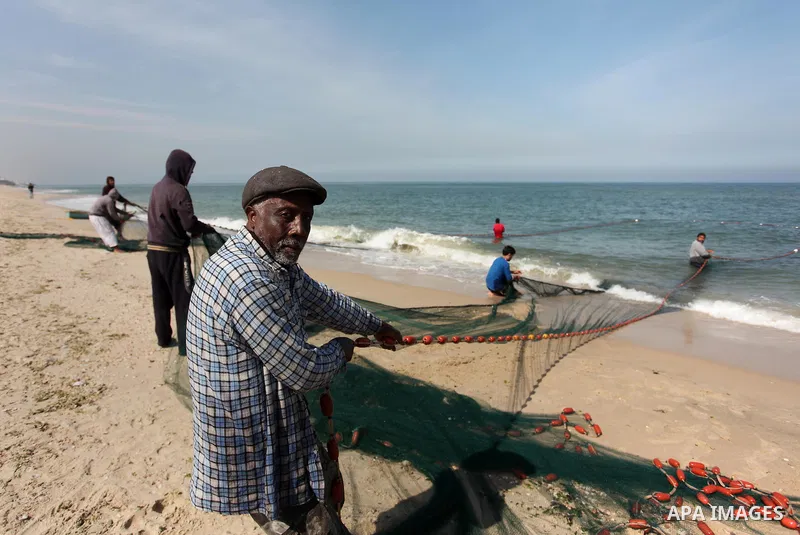 Palestinian fishermen pull their net at the beach in Gaza City on April 03, 2016. Israel on Sunday extended the distance it permits Gaza fishermen to head out to sea along certain parts of the coastline of the enclave, w...