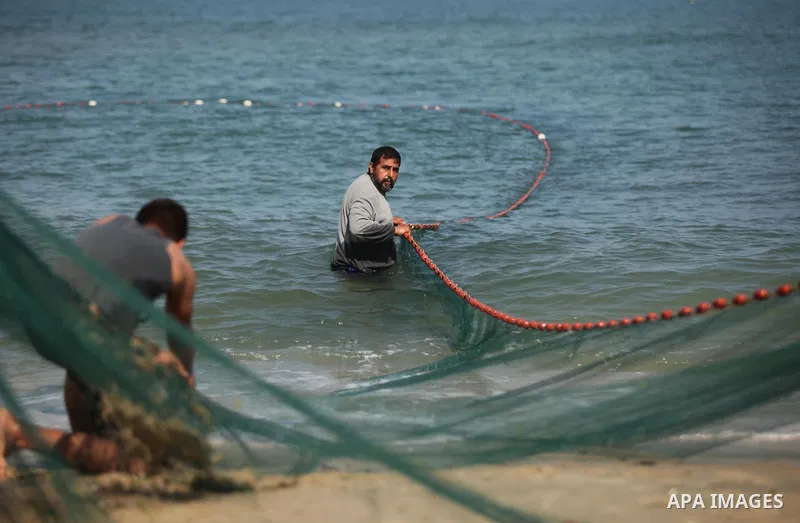 Palestinian fishermen pull their net at the beach in Gaza City on April 03, 2016. Israel on Sunday extended the distance it permits Gaza fishermen to head out to sea along certain parts of the coastline of the enclave, w...