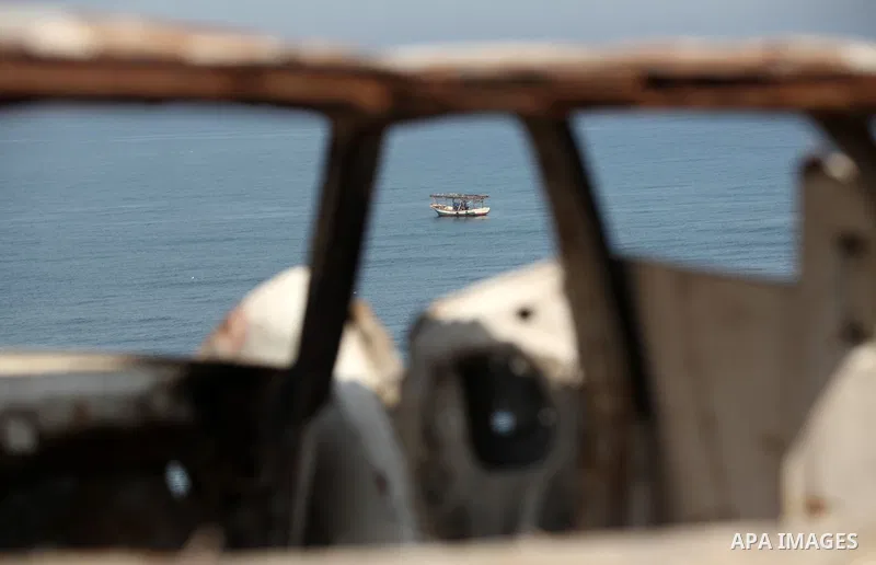 Palestinian fishermen work at the beach in Dair Al Balah in the center of Gaza strip on April 03, 2016. Israel on Sunday extended the distance it permits Gaza fishermen to head out to sea along certain parts of the coast...