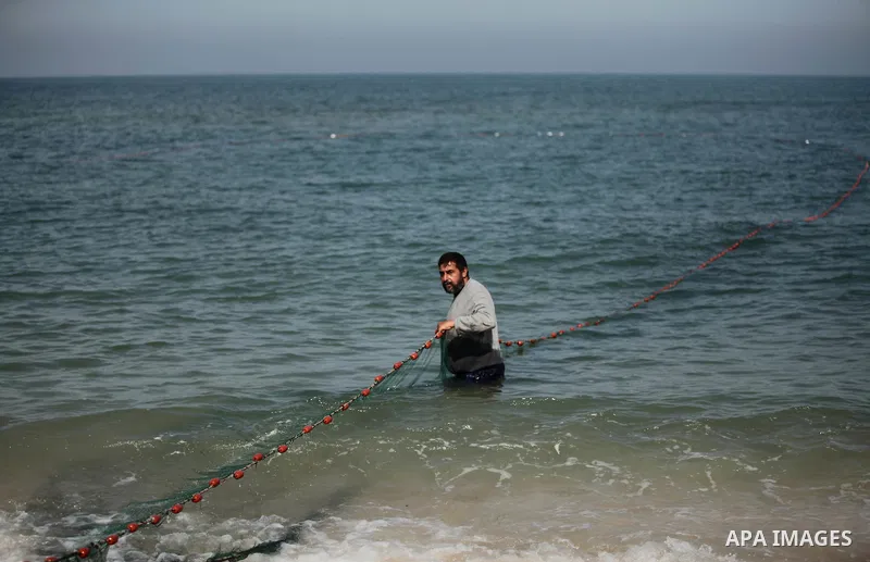 Palestinian fishermen pull their net at the beach in Gaza City on April 03, 2016. Israel on Sunday extended the distance it permits Gaza fishermen to head out to sea along certain parts of the coastline of the enclave, w...