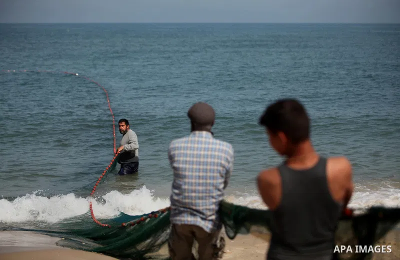 Palestinian fishermen pull their net at the beach in Gaza City on April 03, 2016. Israel on Sunday extended the distance it permits Gaza fishermen to head out to sea along certain parts of the coastline of the enclave, w...