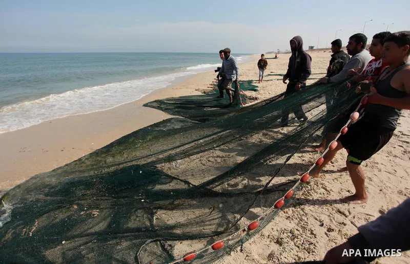Palestinian fishermen pull their net at the beach in Gaza City on April 03, 2016. Israel on Sunday extended the distance it permits Gaza fishermen to head out to sea along certain parts of the coastline of the enclave, w...
