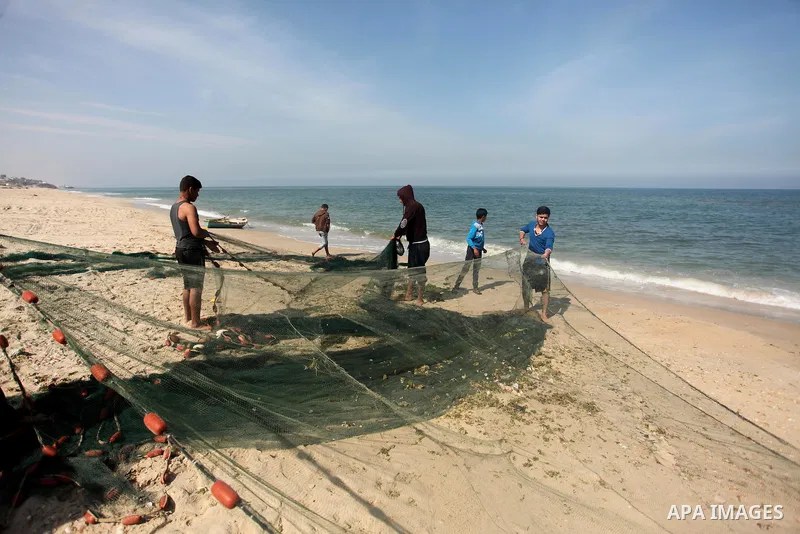 Palestinian fishermen pull their net at the beach in Gaza City on April 03, 2016. Israel on Sunday extended the distance it permits Gaza fishermen to head out to sea along certain parts of the coastline of the enclave, w...