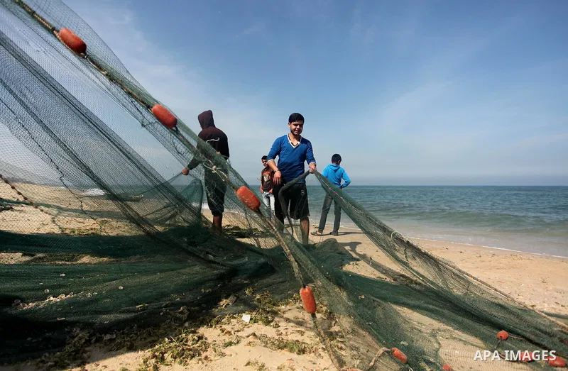 Palestinian fishermen pull their net at the beach in Gaza City on April 03, 2016. Israel on Sunday extended the distance it permits Gaza fishermen to head out to sea along certain parts of the coastline of the enclave, w...