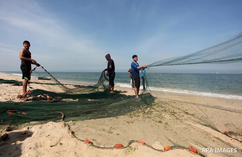 Palestinian fishermen pull their net at the beach in Gaza City on April 03, 2016. Israel on Sunday extended the distance it permits Gaza fishermen to head out to sea along certain parts of the coastline of the enclave, w...