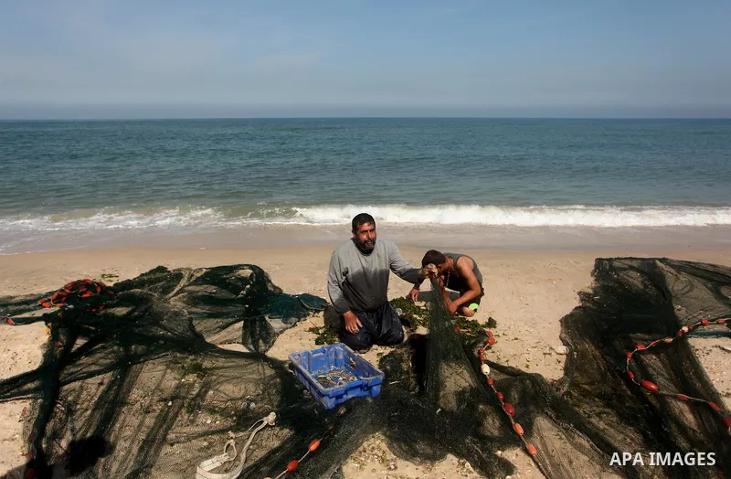 Palestinian fishermen throw thier nets into the sea at the beach of Gaza City on April 03, 2016. Israel on Sunday extended the distance it permits Gaza fishermen to head out to sea along certain parts of the coastline of...
