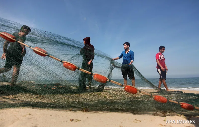 Palestinian fishermen pull their net at the beach in Gaza City on April 03, 2016. Israel on Sunday extended the distance it permits Gaza fishermen to head out to sea along certain parts of the coastline of the enclave, w...