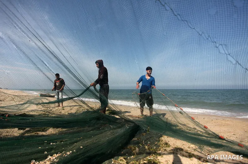 Palestinian fishermen throw thier nets into the sea at the beach of Gaza City on April 03, 2016. Israel on Sunday extended the distance it permits Gaza fishermen to head out to sea along certain parts of the coastline of...