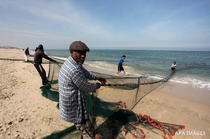 Palestinian fishermen pull their net at the beach in Gaza City on April 03, 2016. Israel on Sunday extended the distance it permits Gaza fishermen to head out to sea along certain parts of the coastline of the enclave, w...