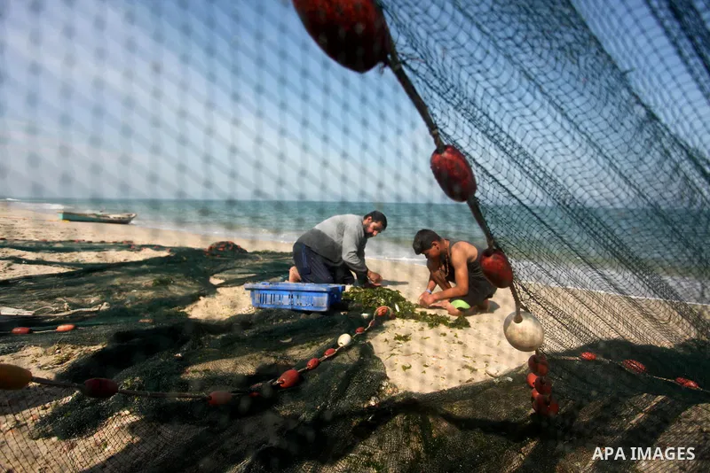 Palestinian fishermen throw thier nets into the sea at the beach of Gaza City on April 03, 2016. Israel on Sunday extended the distance it permits Gaza fishermen to head out to sea along certain parts of the coastline of...
