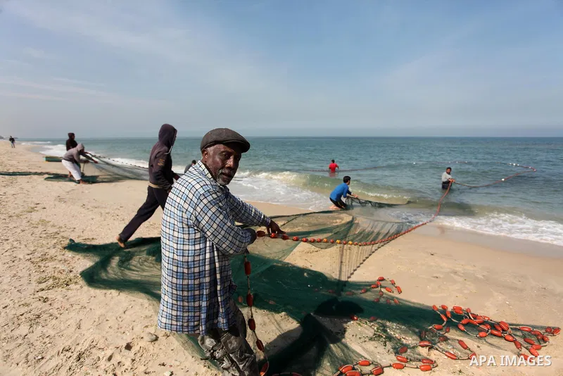 Palestinian fishermen pull their net at the beach in Gaza City on April 03, 2016. Israel on Sunday extended the distance it permits Gaza fishermen to head out to sea along certain parts of the coastline of the enclave, w...