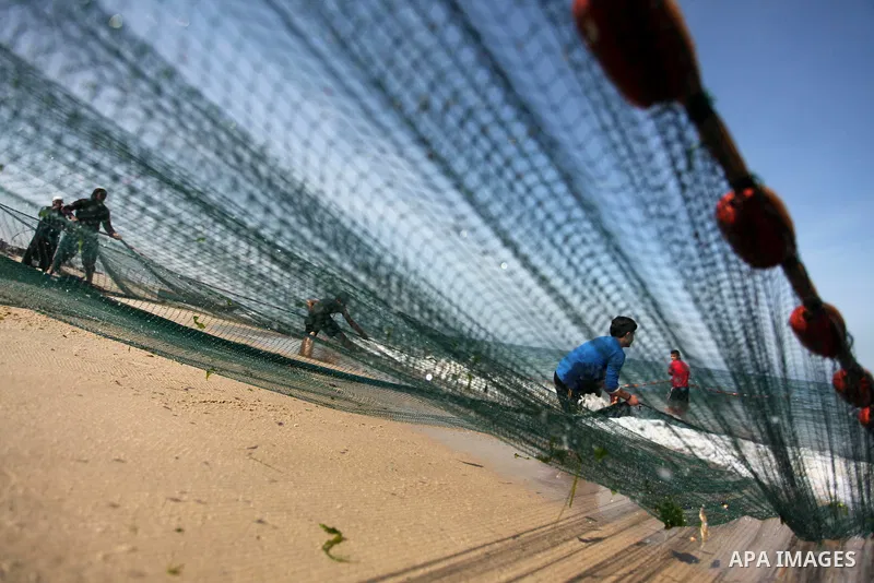 Palestinian fishermen pull their net at the beach in Gaza City on April 03, 2016. Israel on Sunday extended the distance it permits Gaza fishermen to head out to sea along certain parts of the coastline of the enclave, w...