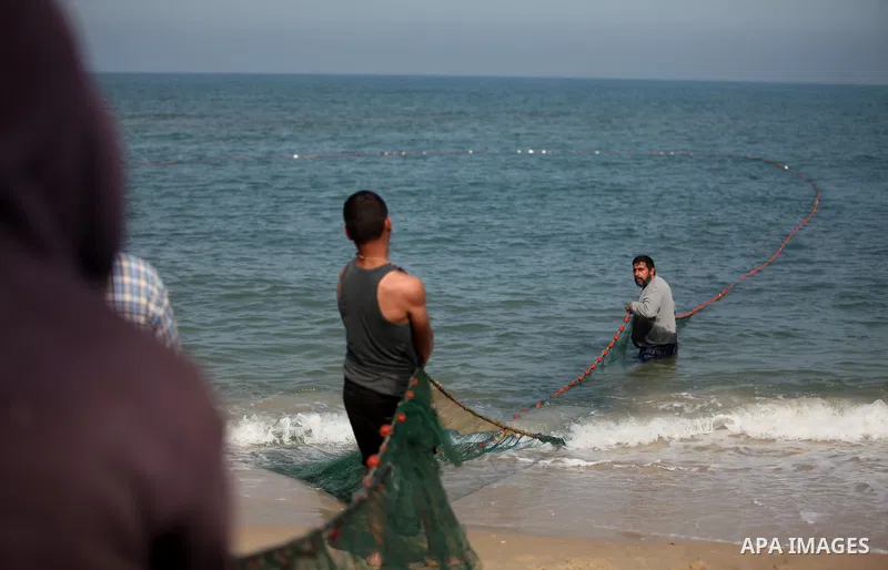 Palestinian fishermen pull their net at the beach in Gaza City on April 03, 2016. Israel on Sunday extended the distance it permits Gaza fishermen to head out to sea along certain parts of the coastline of the enclave, w...
