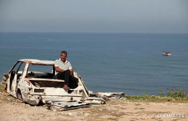 Palestinian fishermen work at the beach in Dair Al Balah in the center of Gaza strip on April 03, 2016. Israel on Sunday extended the distance it permits Gaza fishermen to head out to sea along certain parts of the coast...