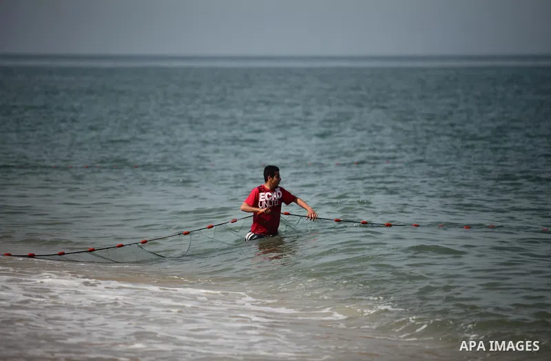 Palestinian fishermen pull their net at the beach in Gaza City on April 03, 2016. Israel on Sunday extended the distance it permits Gaza fishermen to head out to sea along certain parts of the coastline of the enclave, w...